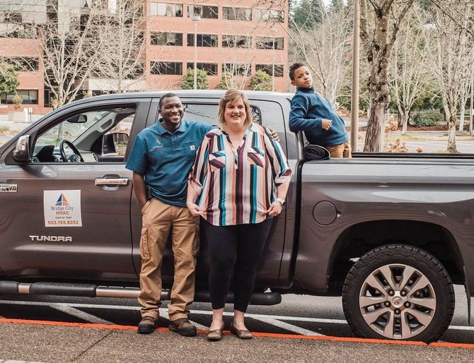 A group of people are standing in front of a truck.