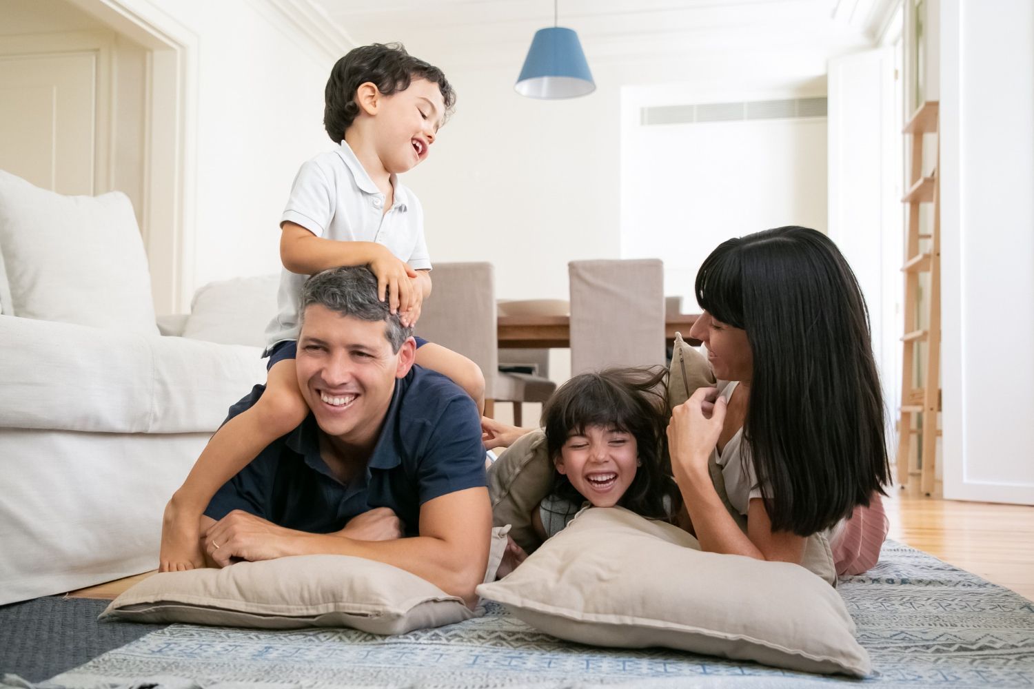 A family is laying on the floor in a living room.