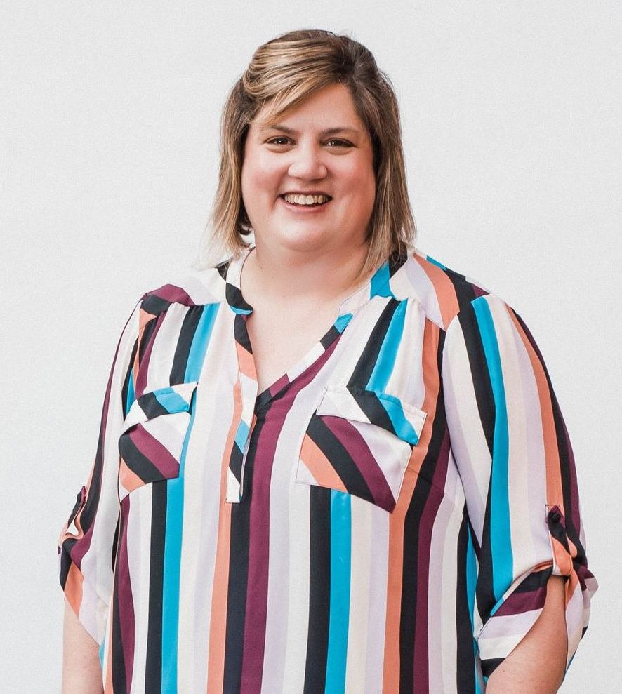 A woman wearing a striped shirt is smiling for the camera.