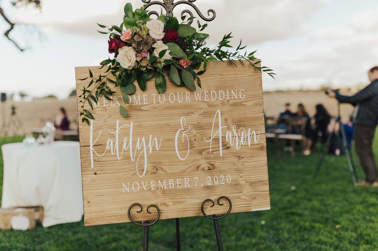 Wooden wedding sign with floral arrangement. 