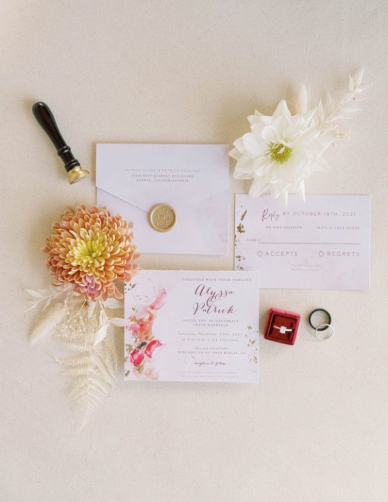 Wedding invitation suite with flowers, rings, and wax seal, beige and floral design.