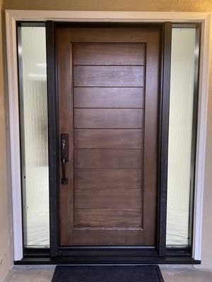 Modern brown front door with sidelights and black trim in a beige entryway