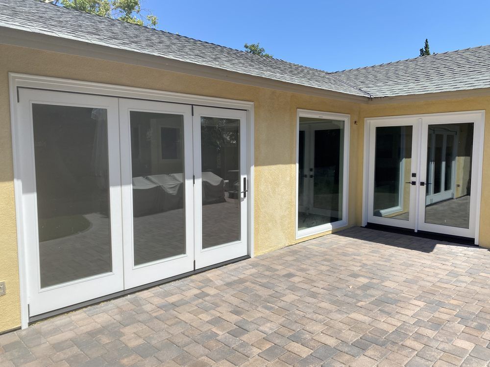Patio with sliding glass doors and a small covered entry on a yellow stucco house