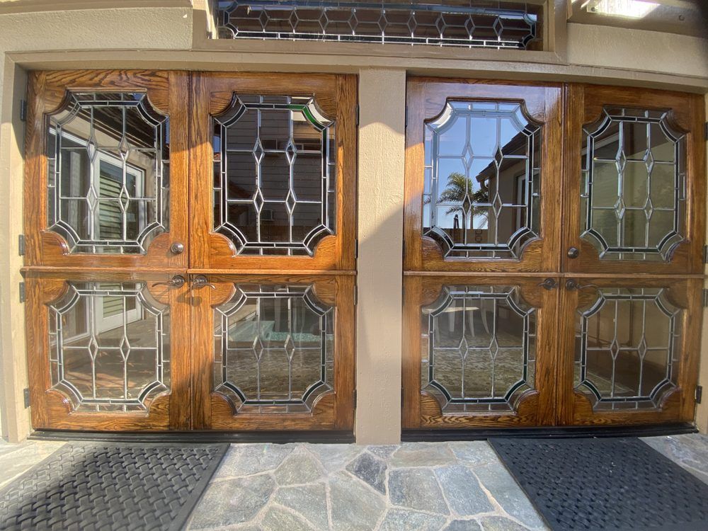 Wooden double front doors with decorative glass panels on a house entrance