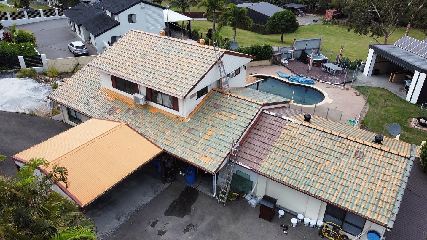 Aerial view of a house with a pool and orange-tiled roof in a suburban setting. - Roof Painting in Gold Coast,QLD