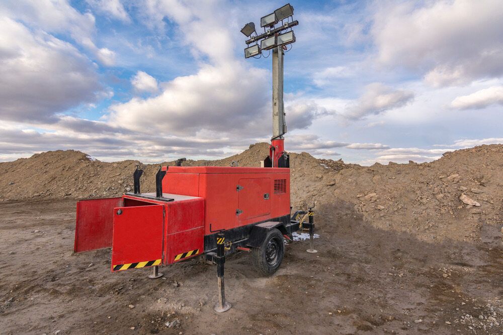 A Red Trailer With a Tower on Top of It is Parked in a Dirt Field — Chaffey Power in Gladstone, QLD