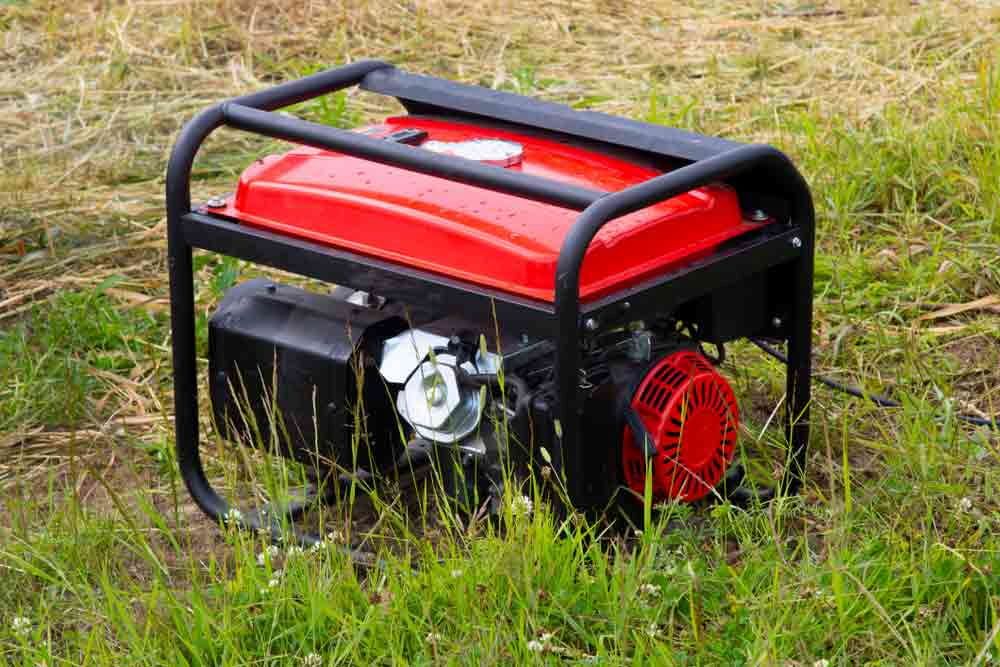 A Red Portable Generator is Sitting in the Grass — Chaffey Power in West Mackay, QLD
