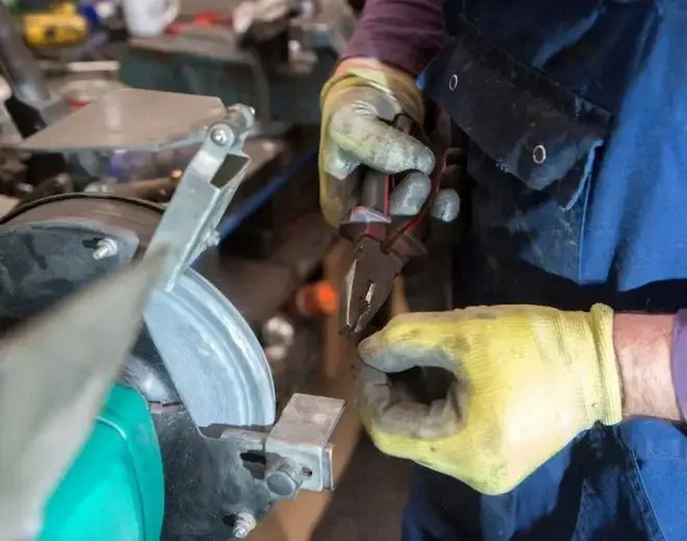 A Person Wearing Yellow Gloves is Holding a Pair of Pliers — Chaffey Power in West Mackay, QLD