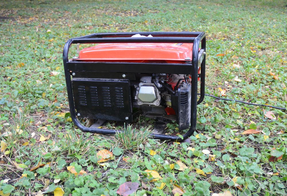 An Orange Generator is Sitting on Top of a Lush Green Field — Chaffey Power in Rockhampton, QLD