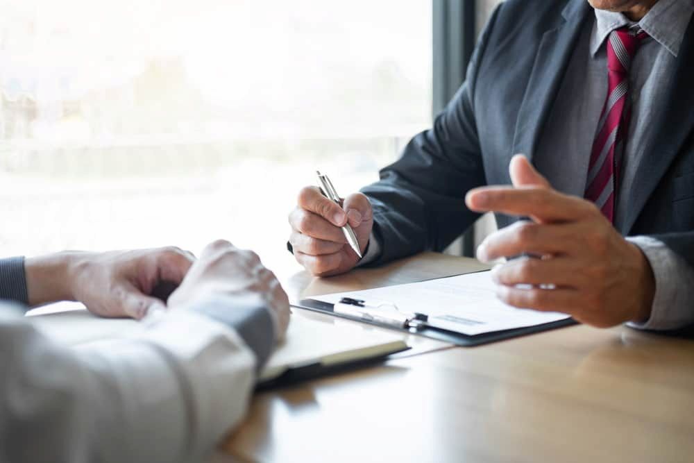 A Man in a Suit and Tie is Sitting at a Table Talking to Another Man — Chaffey Power in West Mackay, QLD