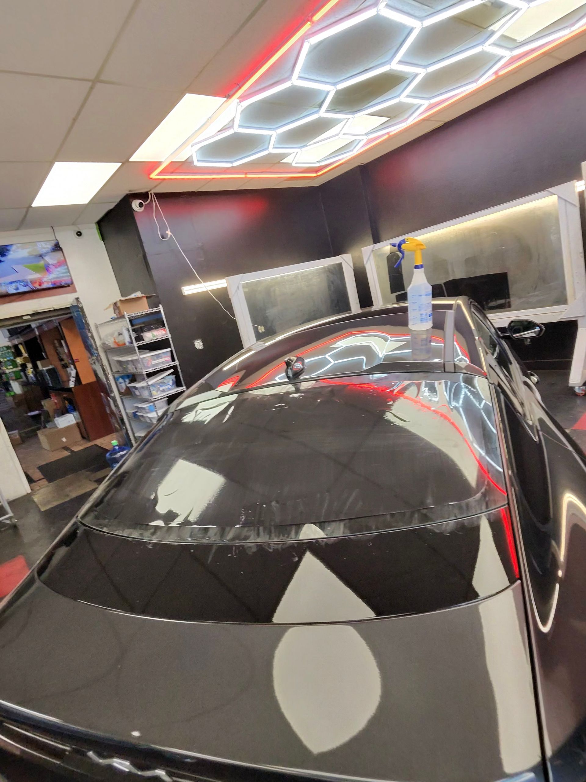 Back glass being tinted in the West Coast tint bay under hexagon lights