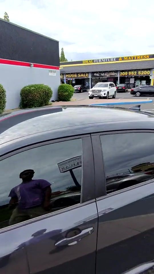 Grey Toyota Corolla with fresh tint parked outside the West Coast Car Audio storefront