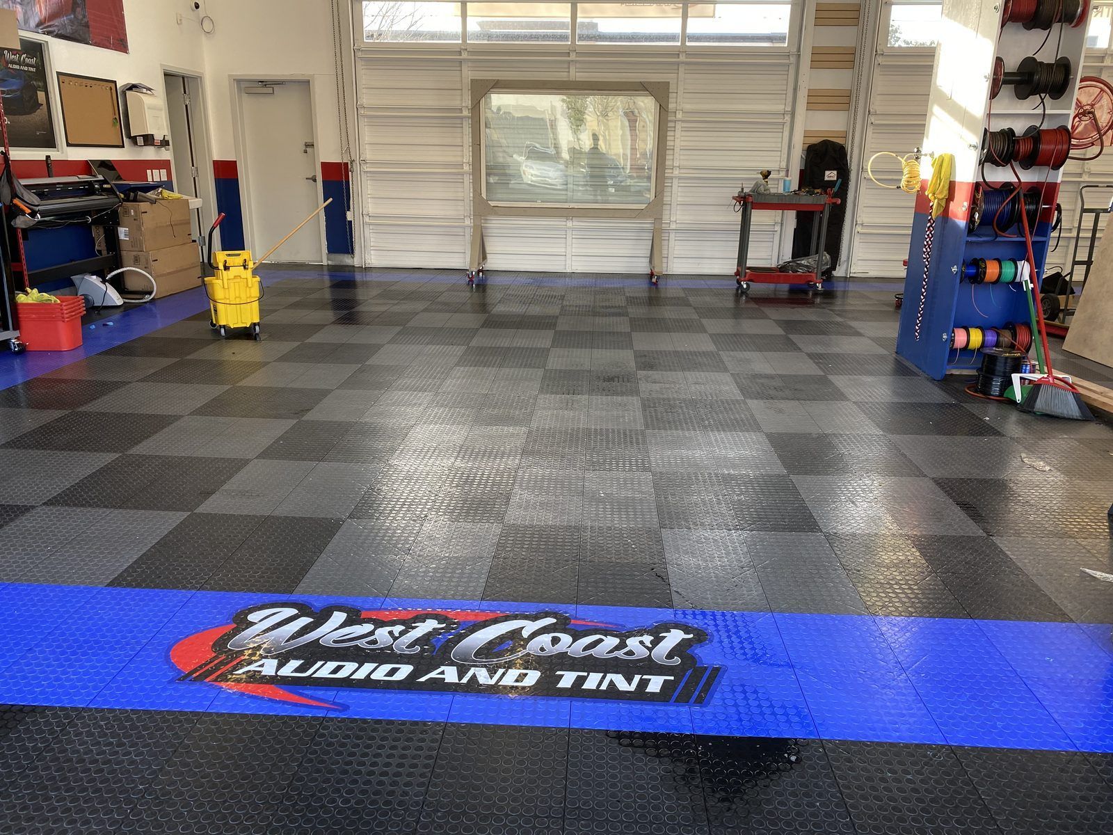 The West Coast install bay with the checkered floor and the West Coast Audio and Tint floor mat