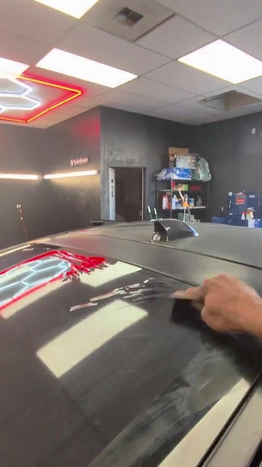 Heat gun shrinking window film to fit a curved back glass