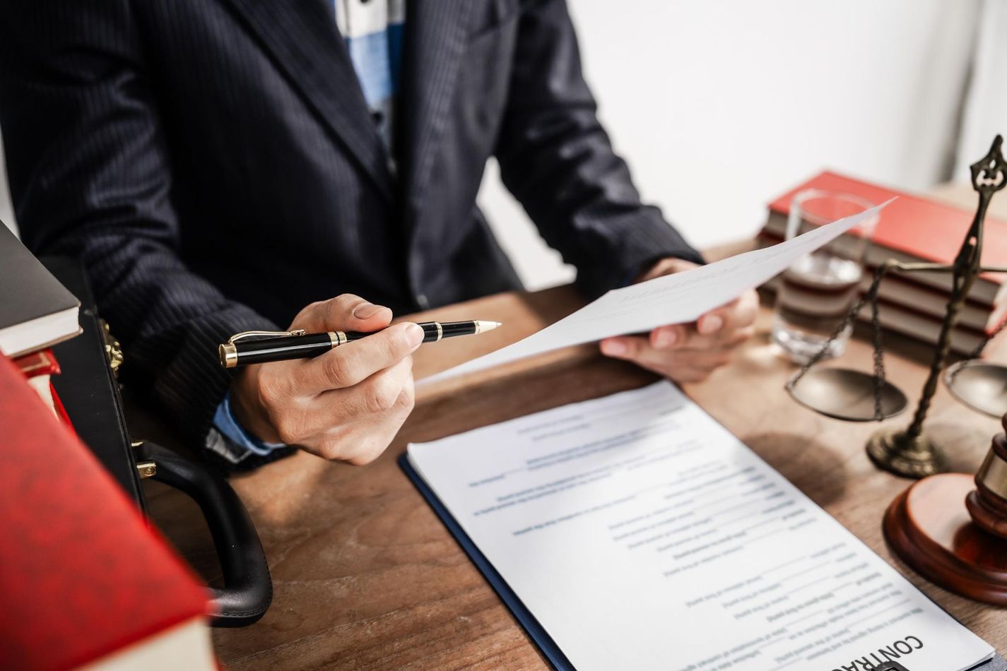 Lawyer reviewing a document at a desk with a gavel and stacked law books