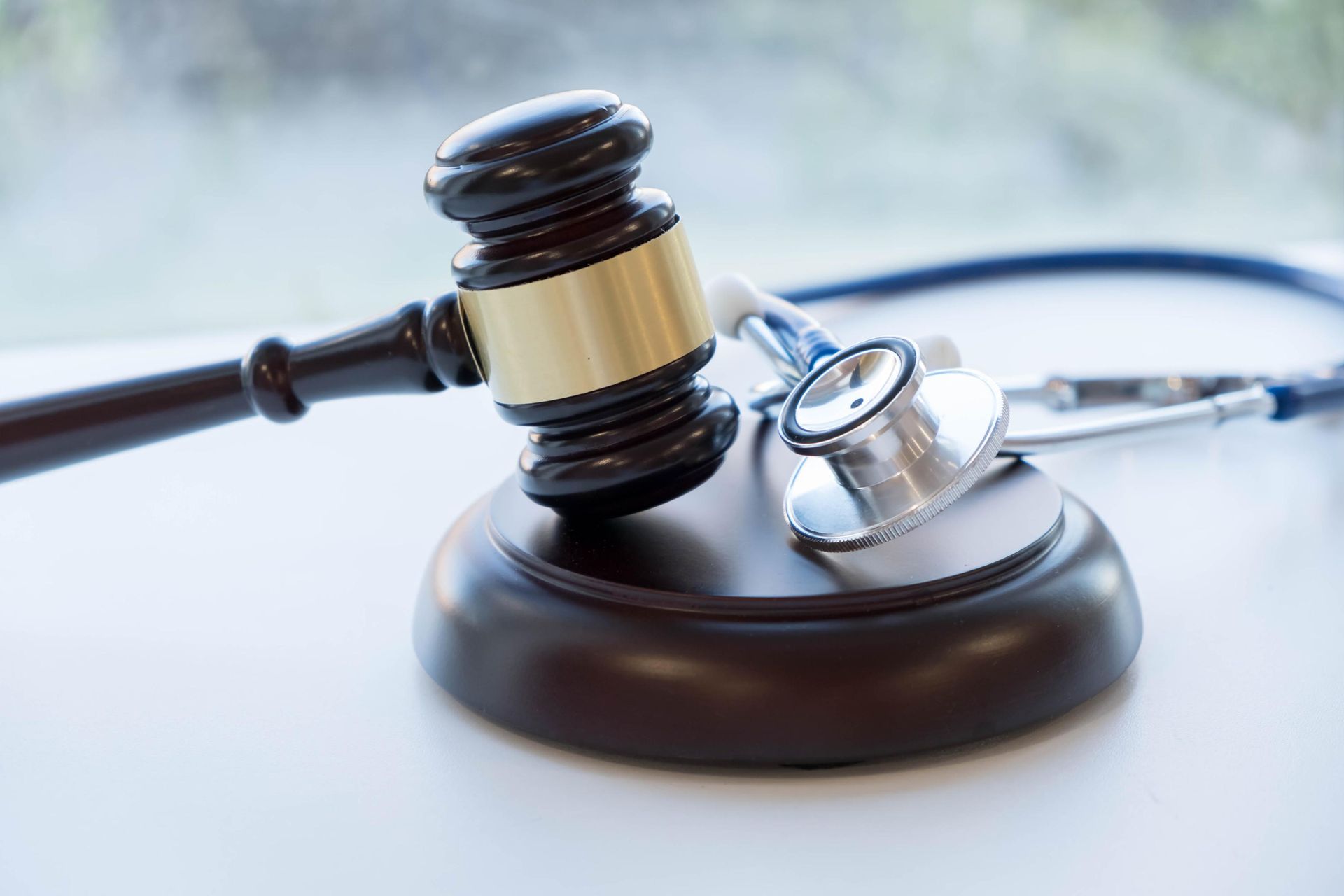 Judge’s gavel beside a stethoscope on a desk, symbolizing medical law or malpractice