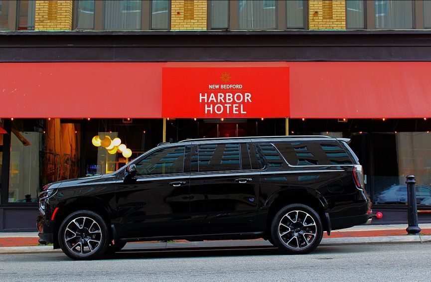 Black SUV parked in front of the red awning of the Harbor Hotel