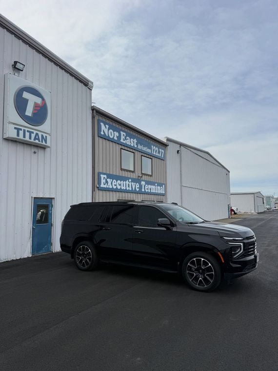 Black SUV parked outside a Titan building on an overcast day.