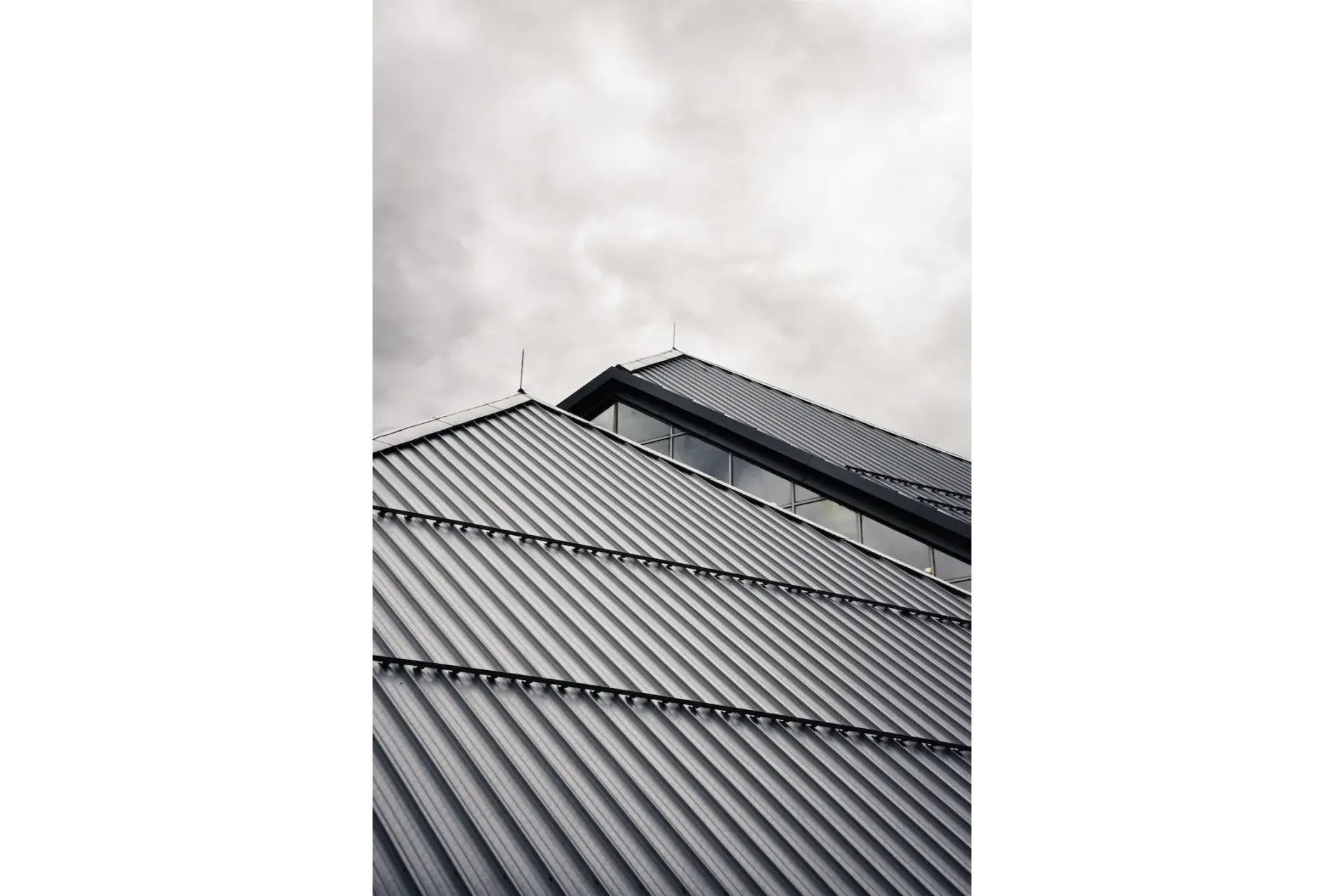 Dark gray tiled roof against a cloudy sky