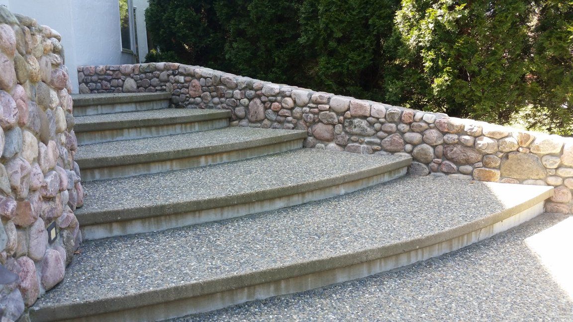 Stone steps with a pebble-like surface lead up to a building, flanked by stone walls.