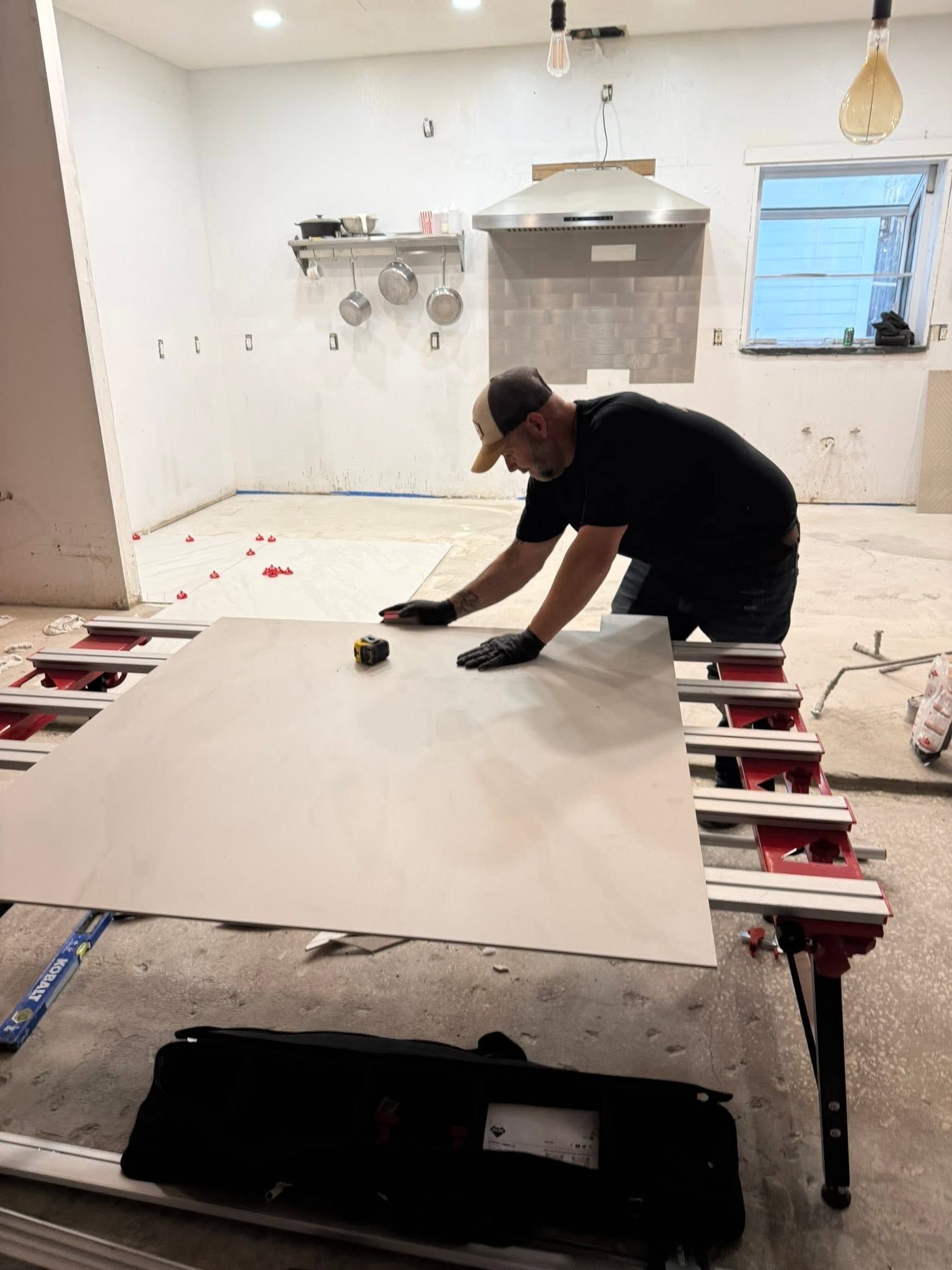 Worker laying a large white sheet on a table in a bright unfinished room