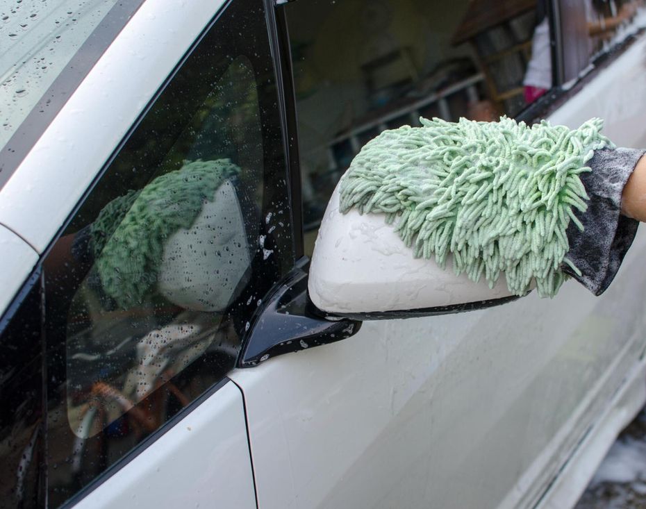 worker wiping the side mirror