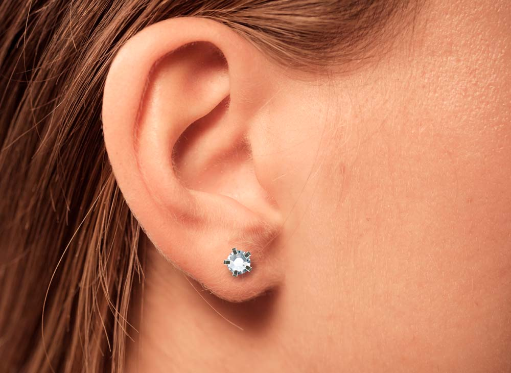 Close-up of an ear wearing a small silver stud earring