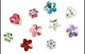 Colorful jeweled flower and heart charms arranged on a white background
