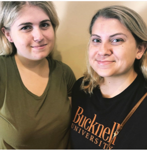 Two women smiling indoors, one in a black Bucknell University T-shirt