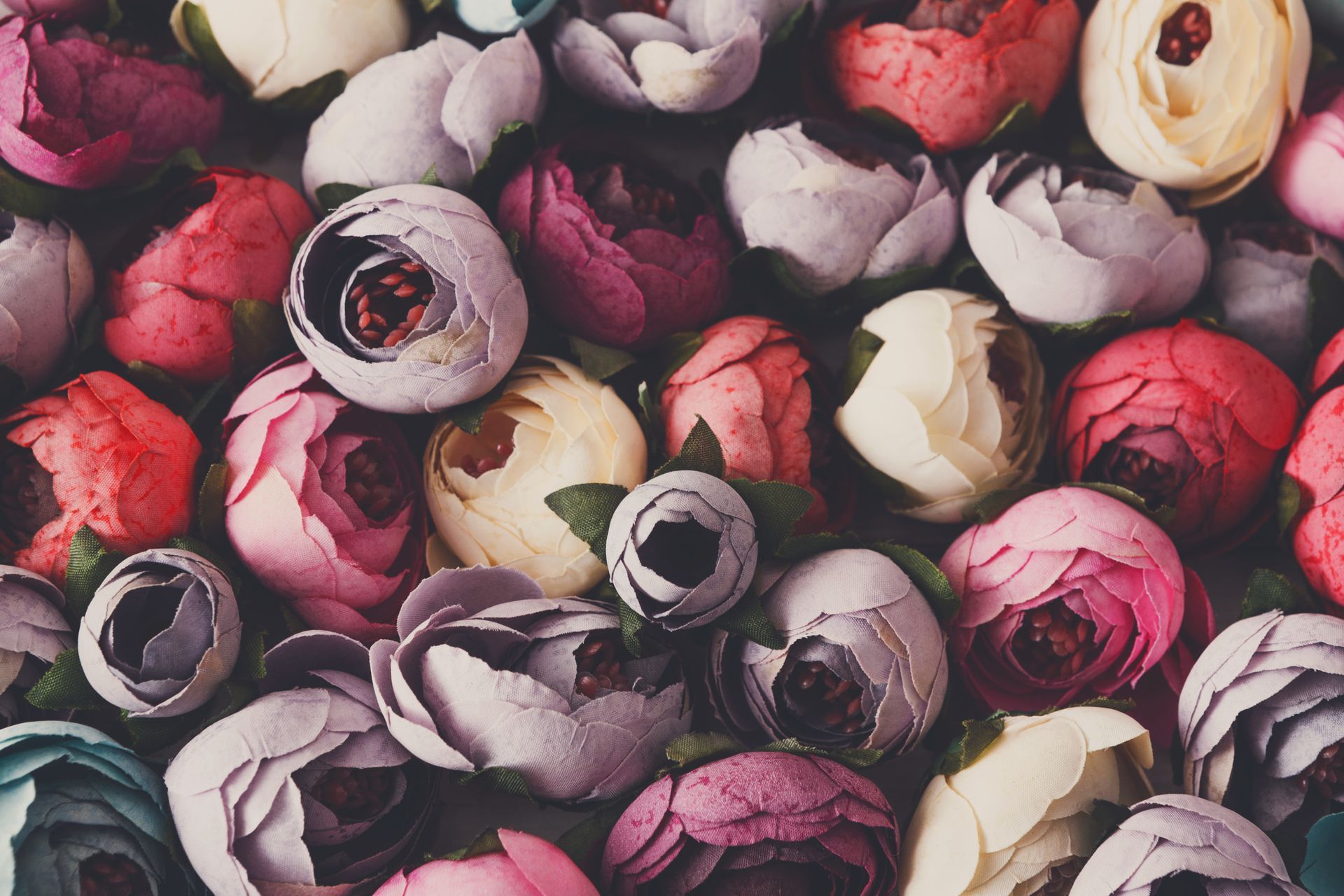 Assorted pink, red, and cream flowers arranged in a dense floral pattern