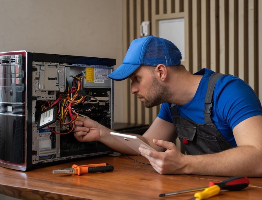 Man in blue T-Shirt Repairs Computer System Unit With Screwdriver — Essential Computer Repairs In Buderim QLD