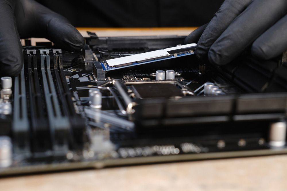 Repairman Holding Hands In Black Gloves Hard Drive SSD To Insert Into The Computer — Essential Computer Repairs In Buderim QLD