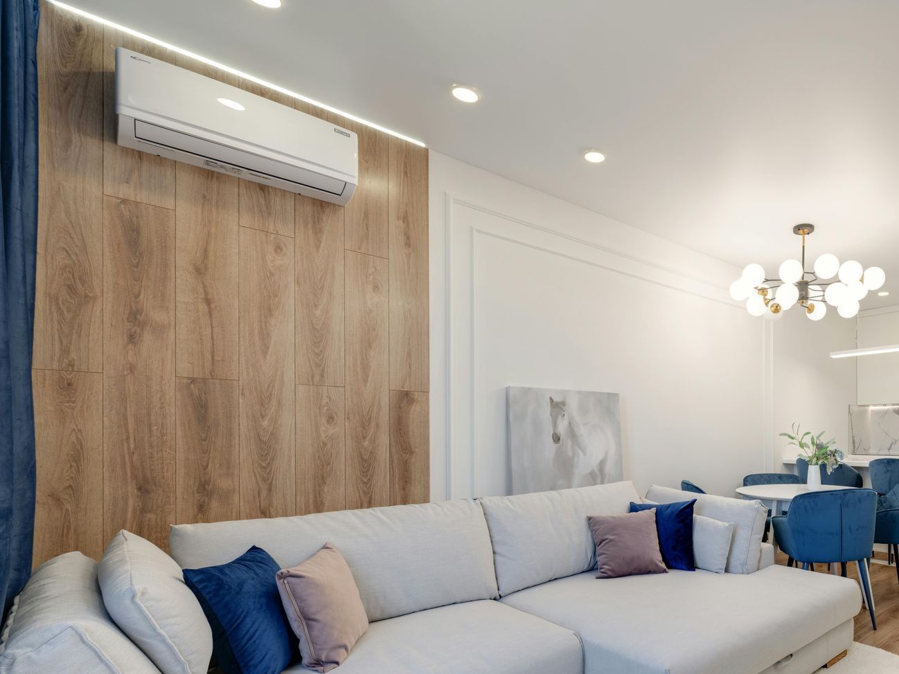A living room with a white couch and a wooden wall.