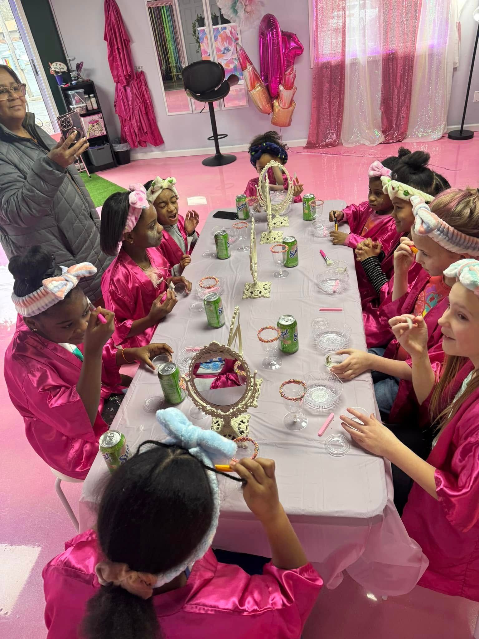 A group of young girls are sitting at a long table.