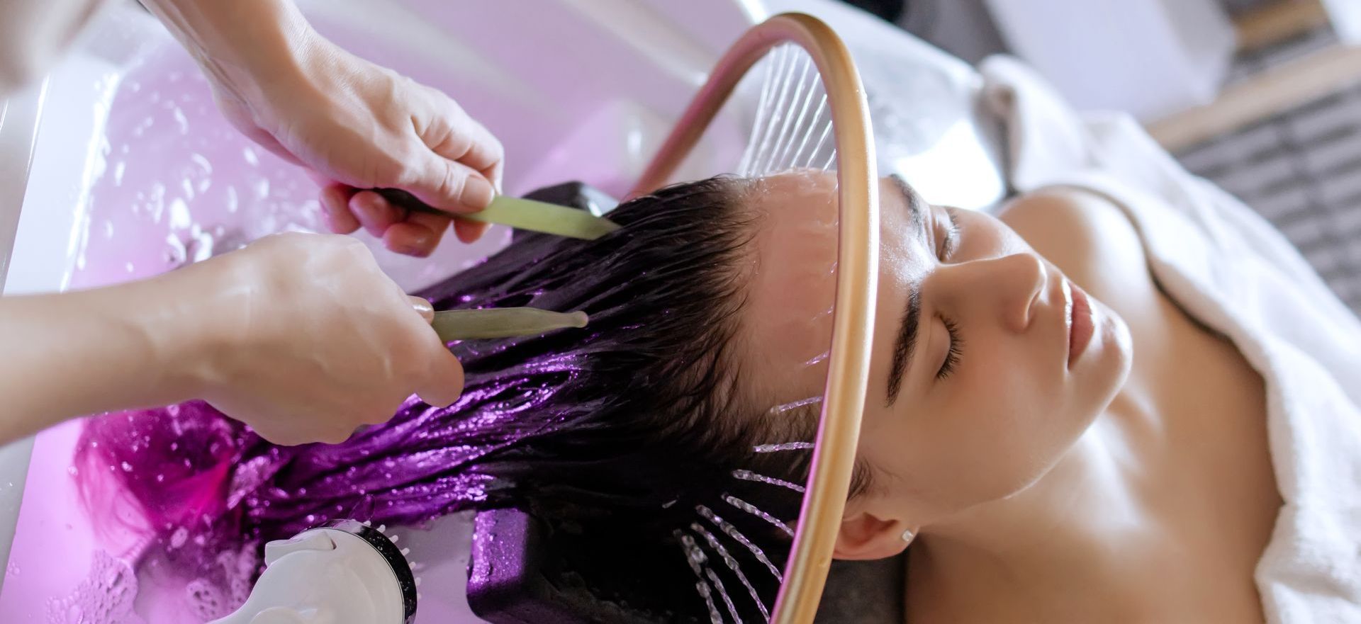 A woman is getting her hair washed at a salon.