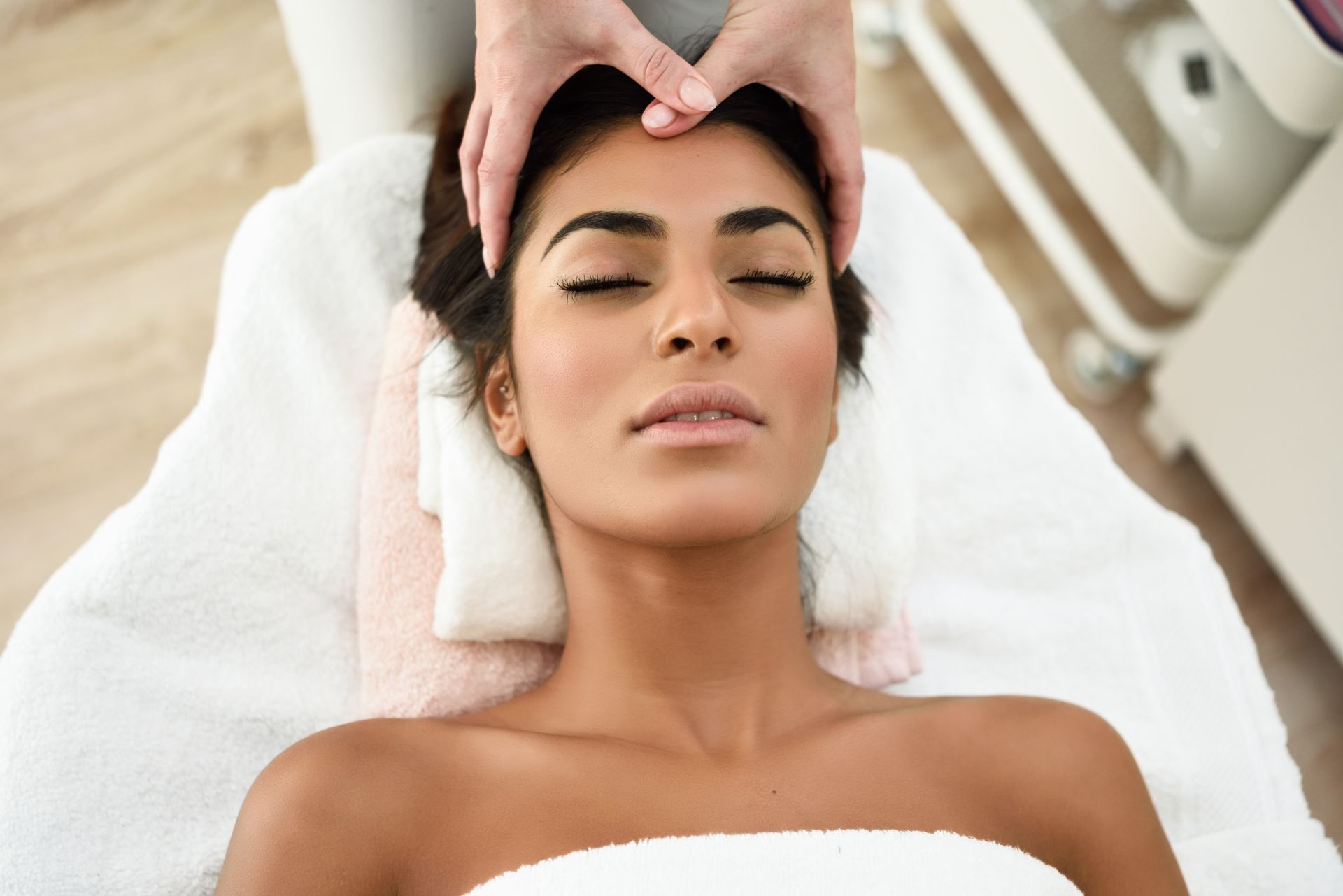 A woman is getting a head massage at a spa.