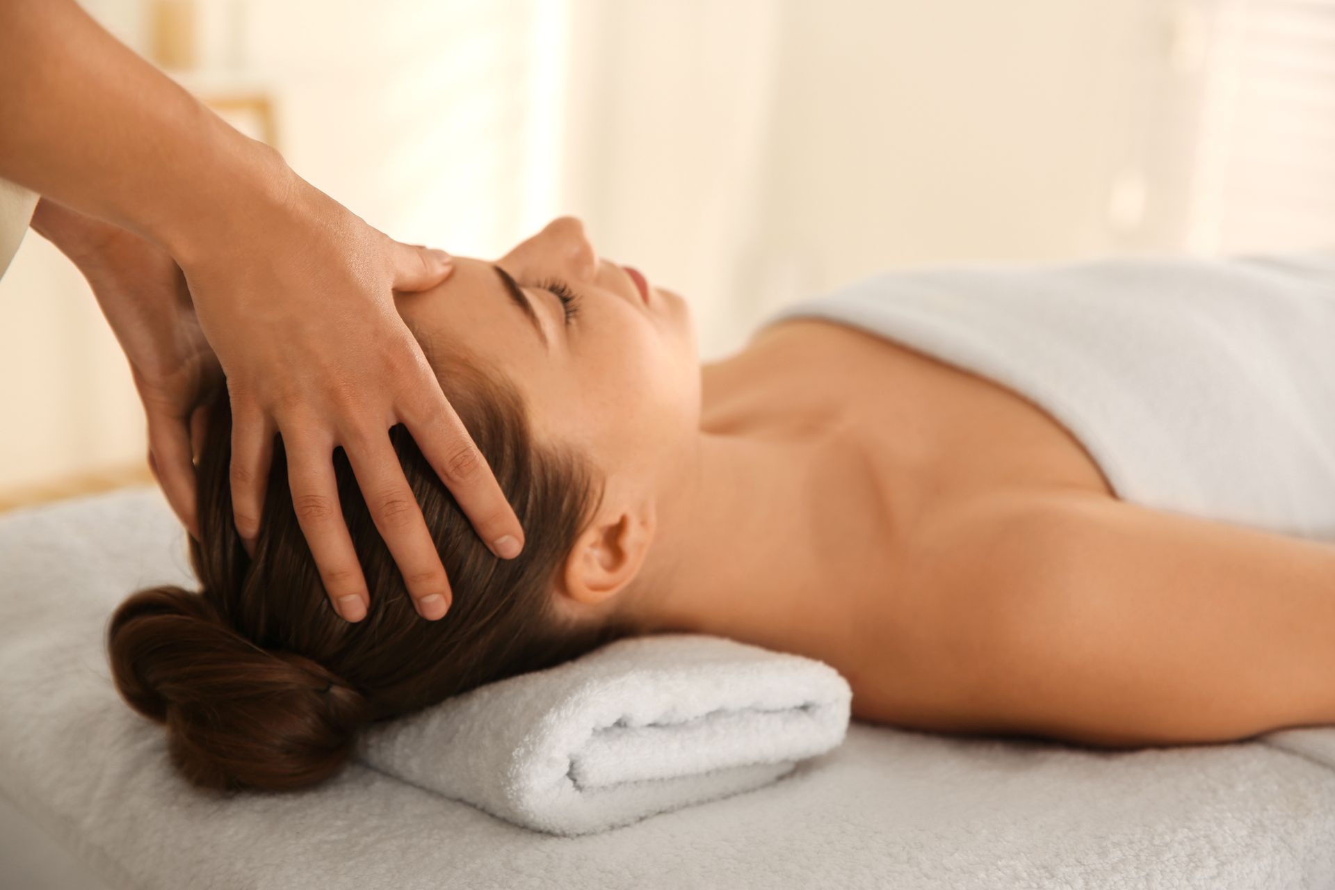 A woman is getting a head massage in a spa.