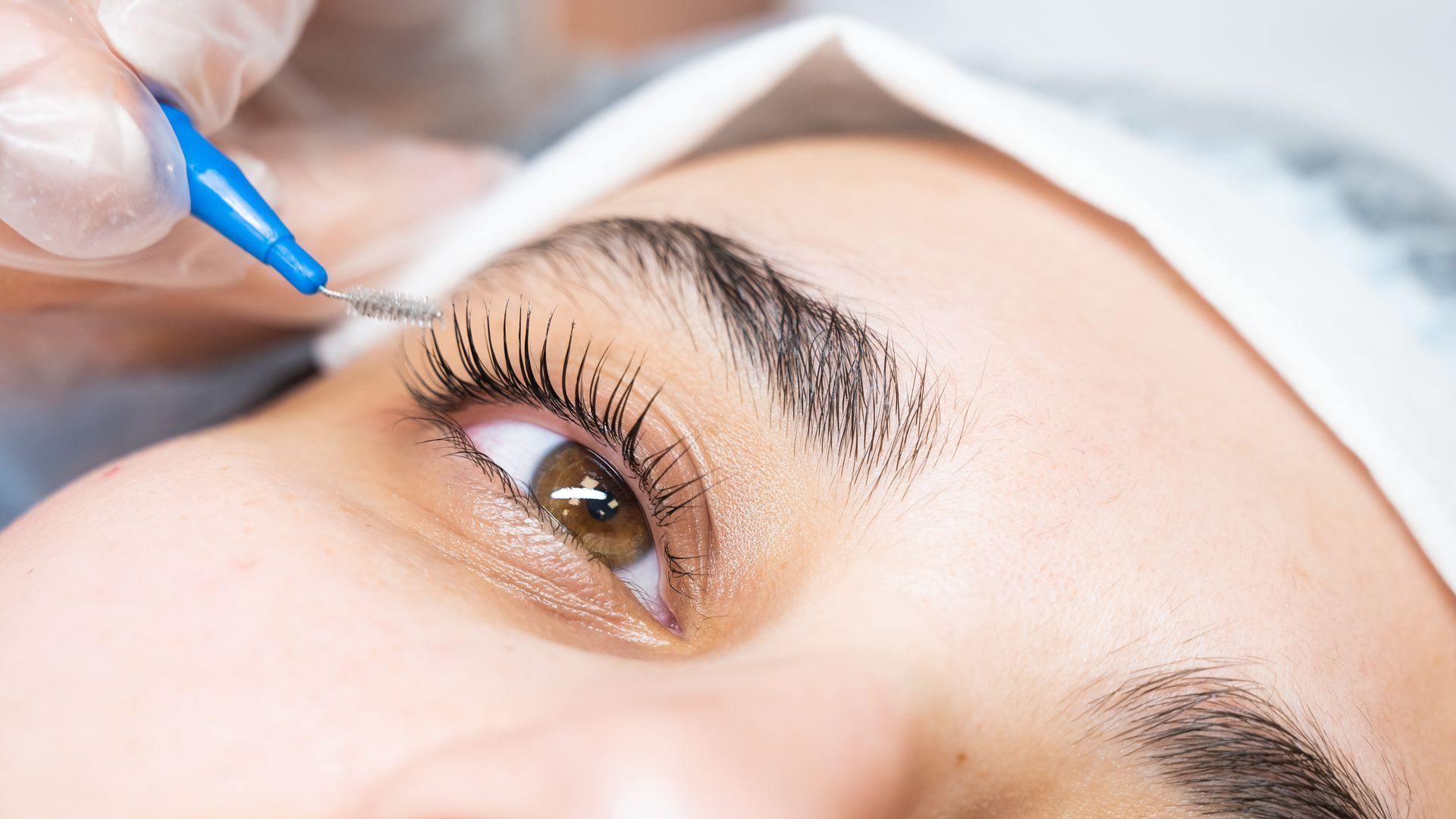 A close up of a woman 's eye with a brush on it.