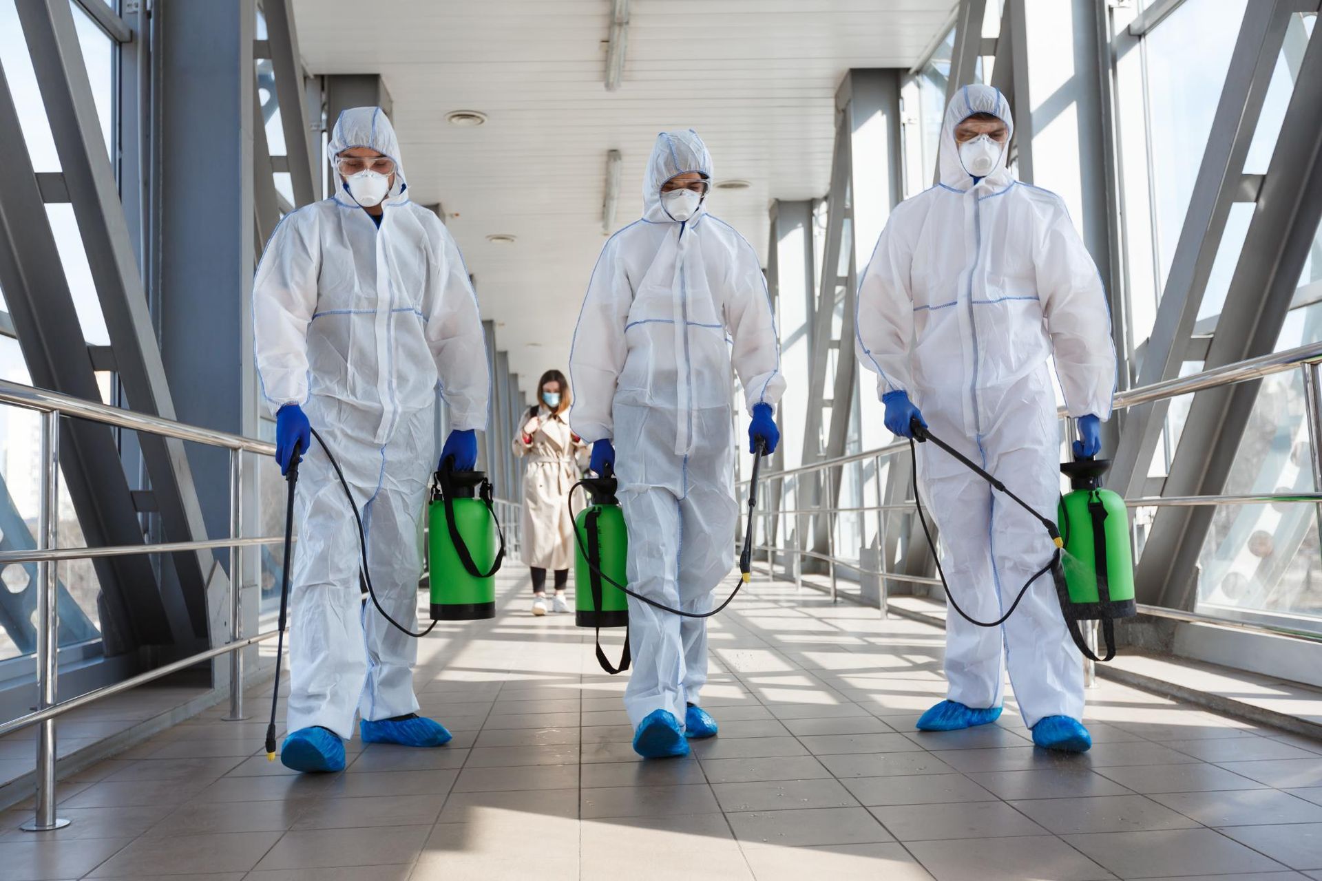 A group of people in protective suits are disinfecting a building.