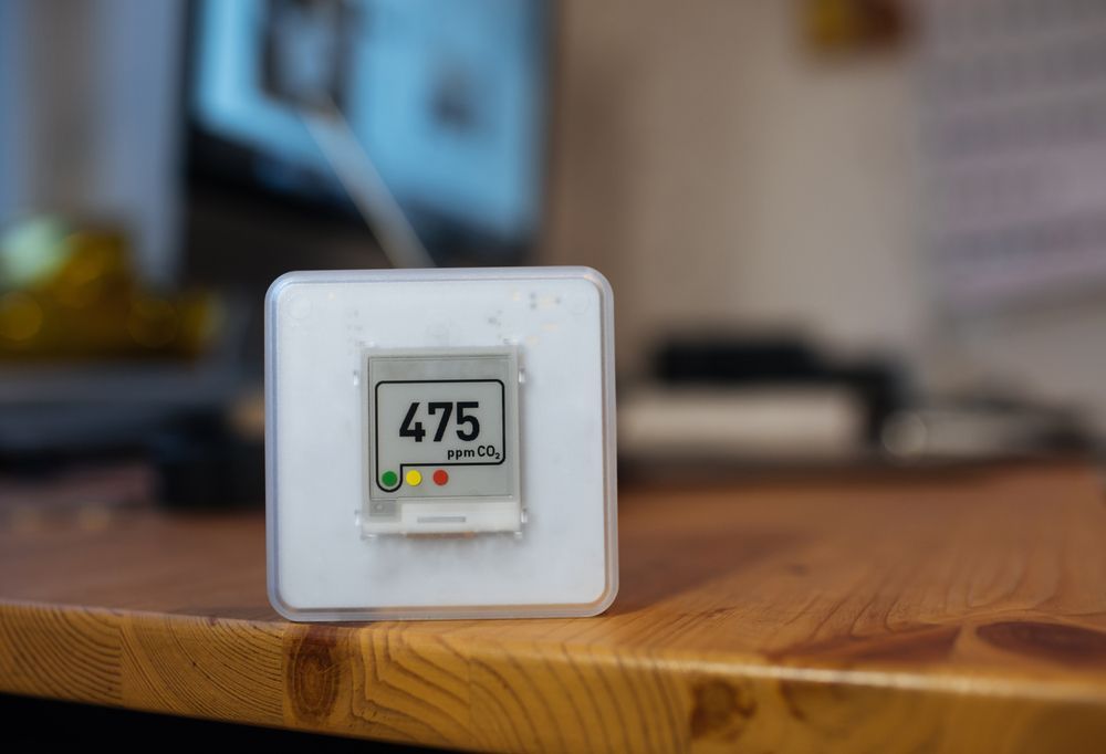 A small electronic device is sitting on a wooden table.