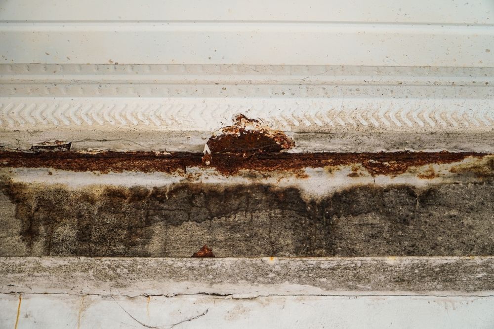 A close up of a rusty piece of metal on a wall.