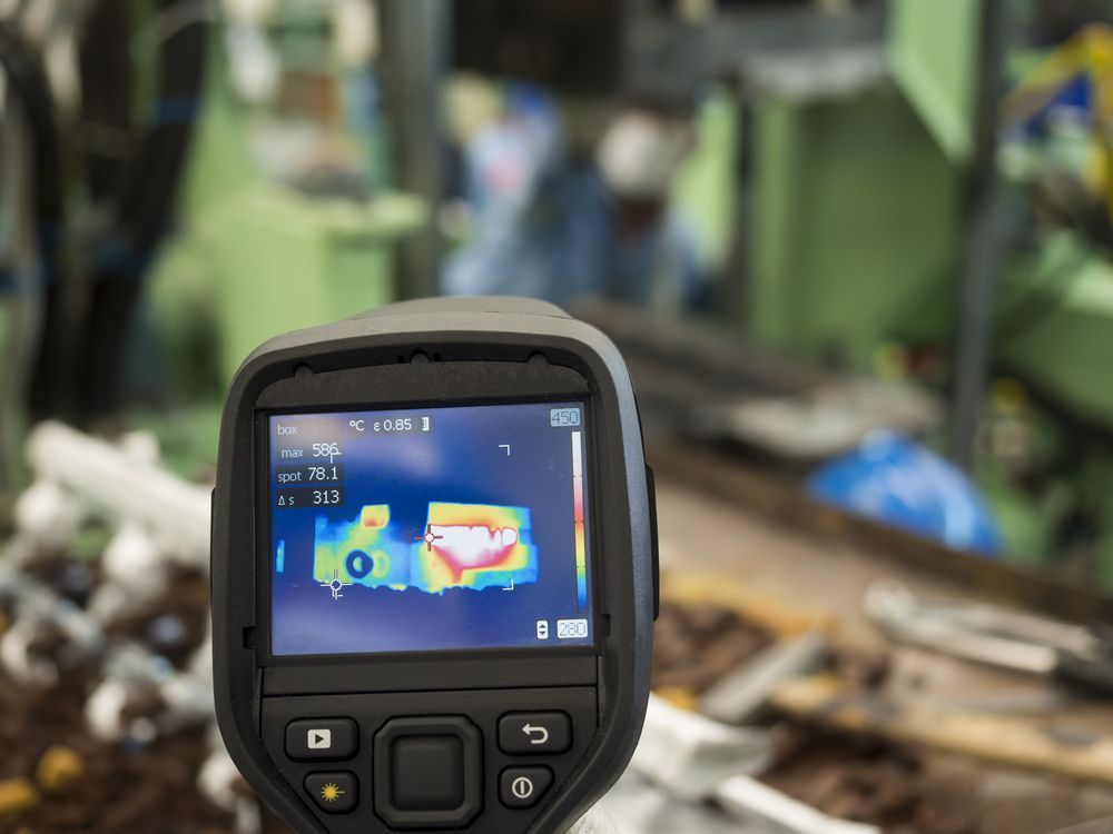 A thermal camera is taking a picture of a machine in a factory.