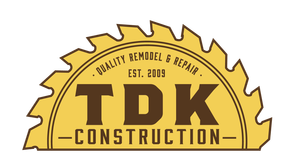 A yellow, semi-circular saw blade logo for TDK Construction, featuring the text