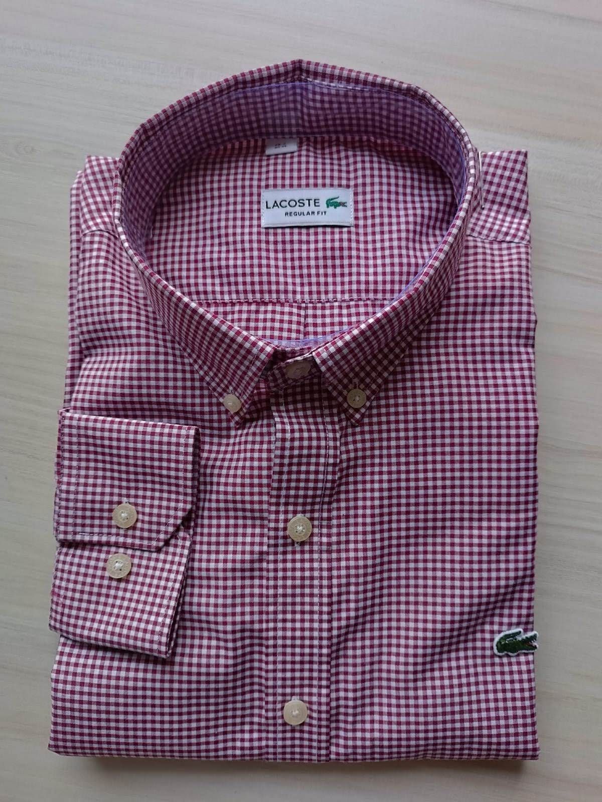 Camisa a cuadros rojos y blancos doblada, con cuello, bolsillos y detalle de pajarita.