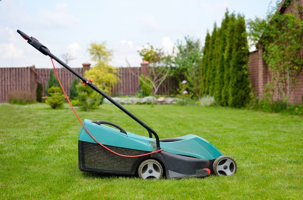 A Teal Lawnmower on a Green Lawn — Professional Small Engines in Mt Isa, QLD