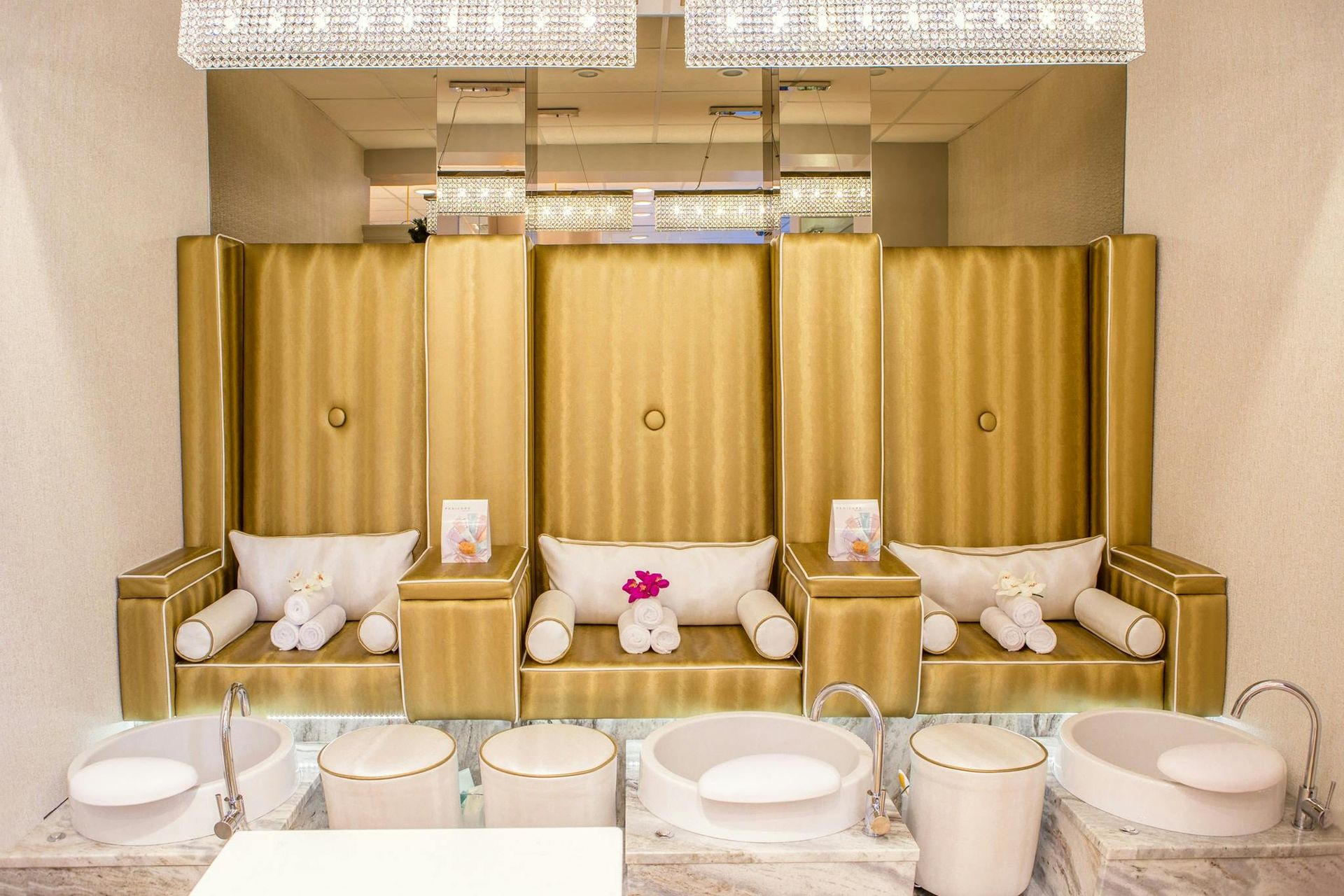 A bathroom with a couch , sinks , and a chandelier.