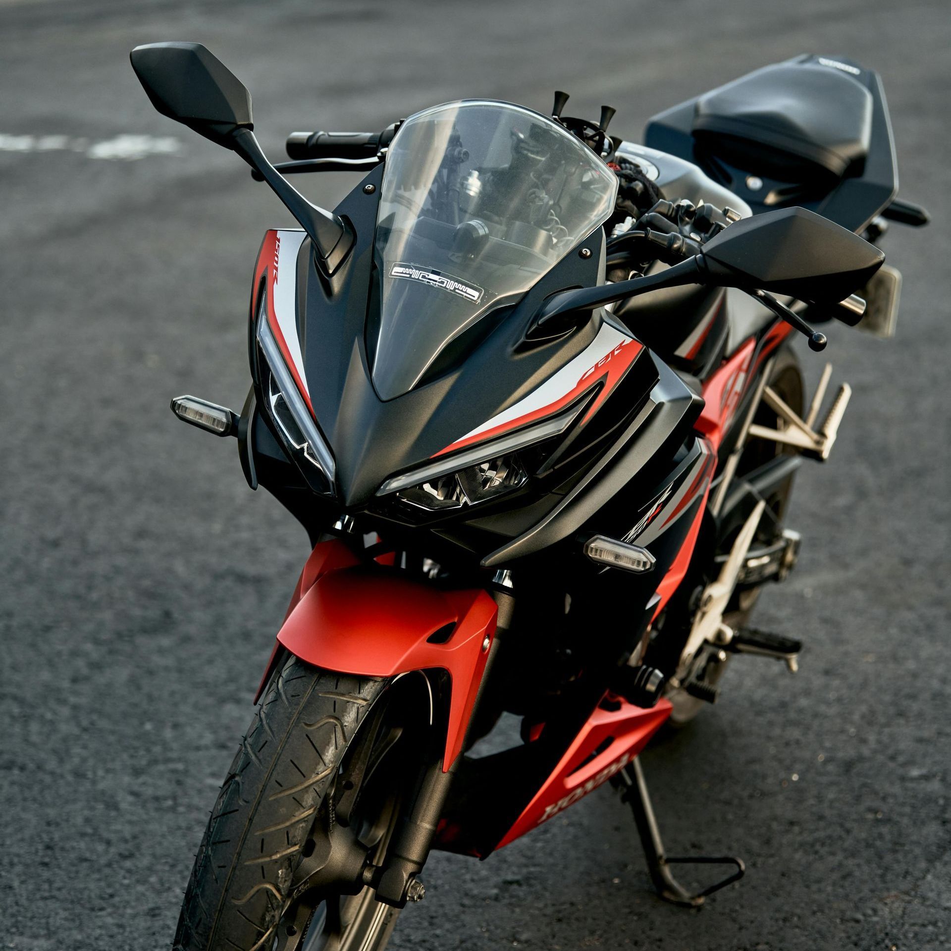A black and red motorcycle is parked on the side of the road.