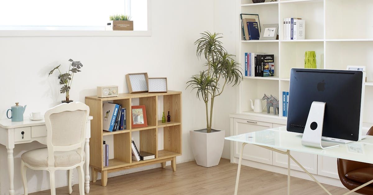 A home office with a desk , chair , computer and shelves.