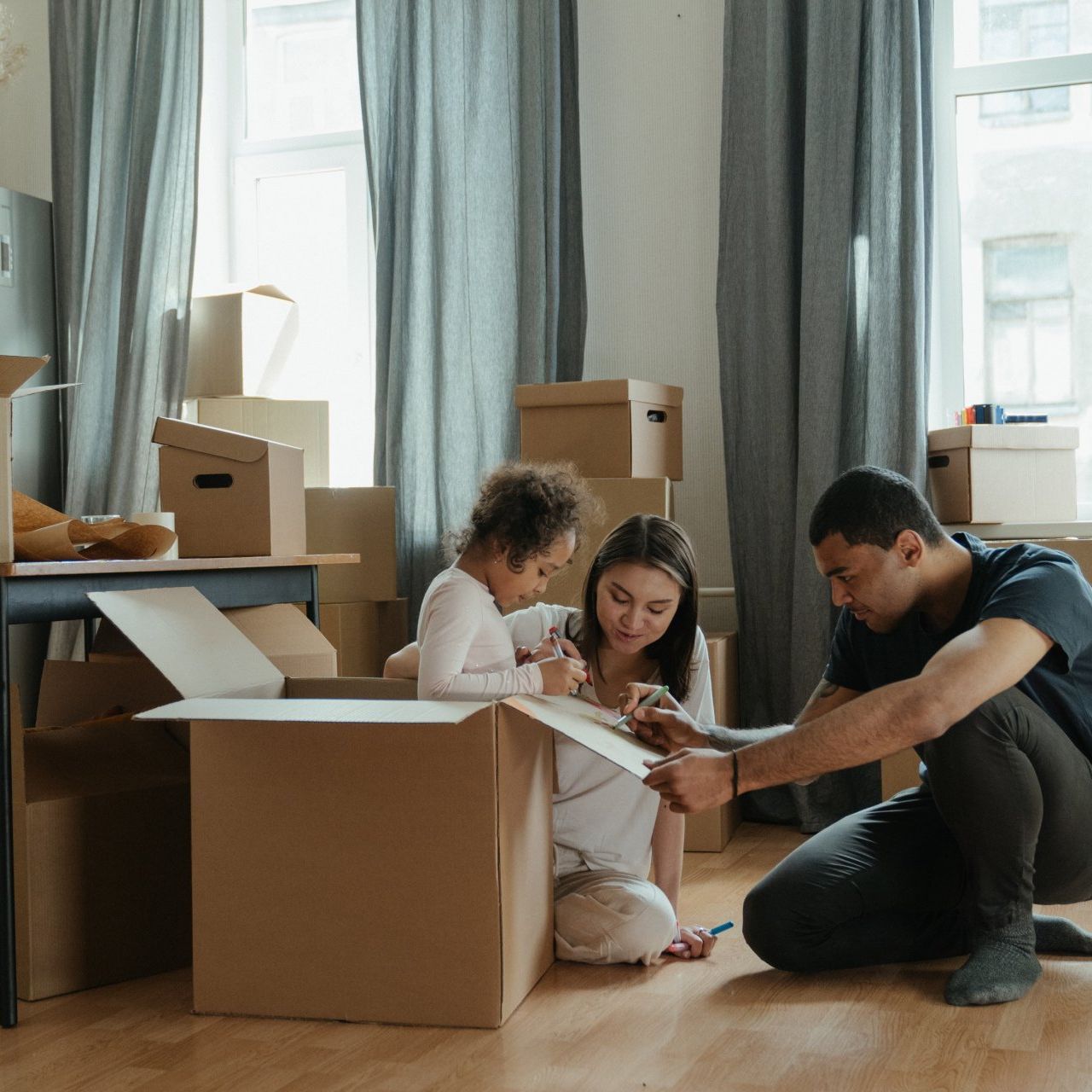 famiglia in casa che si prepara al trasloco sistemando i cartoni