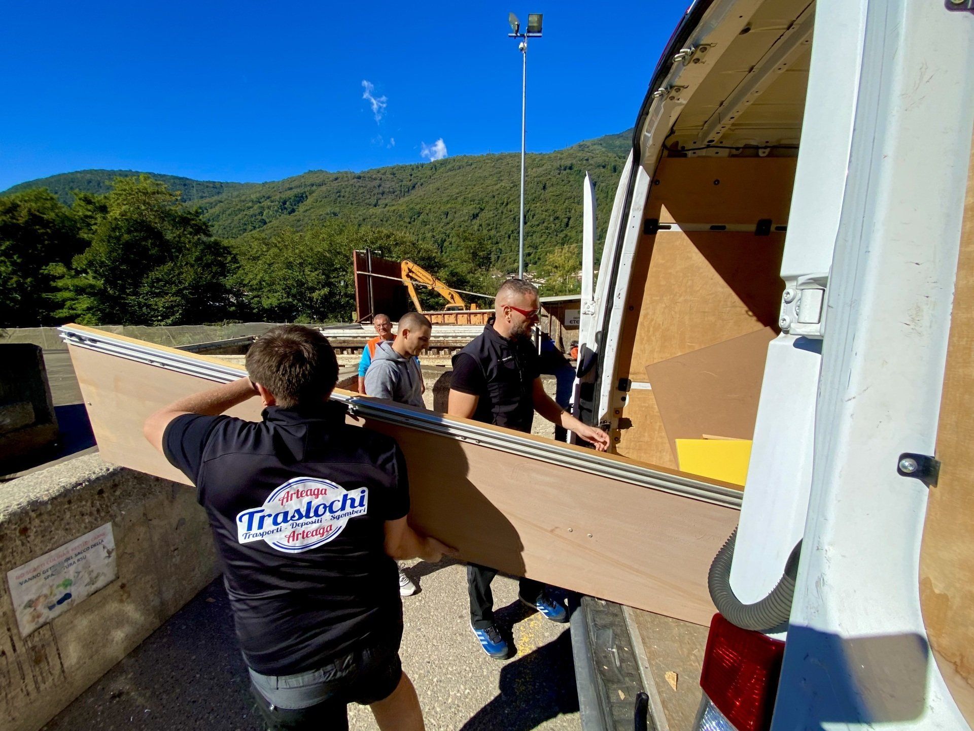 Team Arteaga sta caricando un pezzo di cartone in un furgone per uno sgombero un gruppo di uomini sta caricando un pezzo di cartone in un furgone per uno sgombero